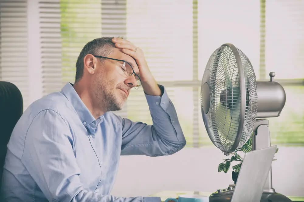 Salarié en plein soleil s'essuyant le front — illustration de la canicule au travail